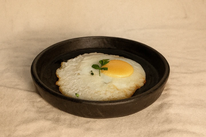 Ovo frito com gema macia, acompanhamento simples e caseiro servido no Dos Baianos Delivery em São José do Rio Preto